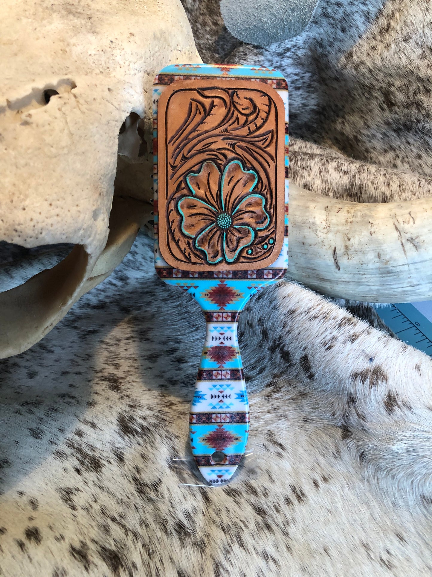 Western tooled leather floral patch on southwestern print paddle brush
