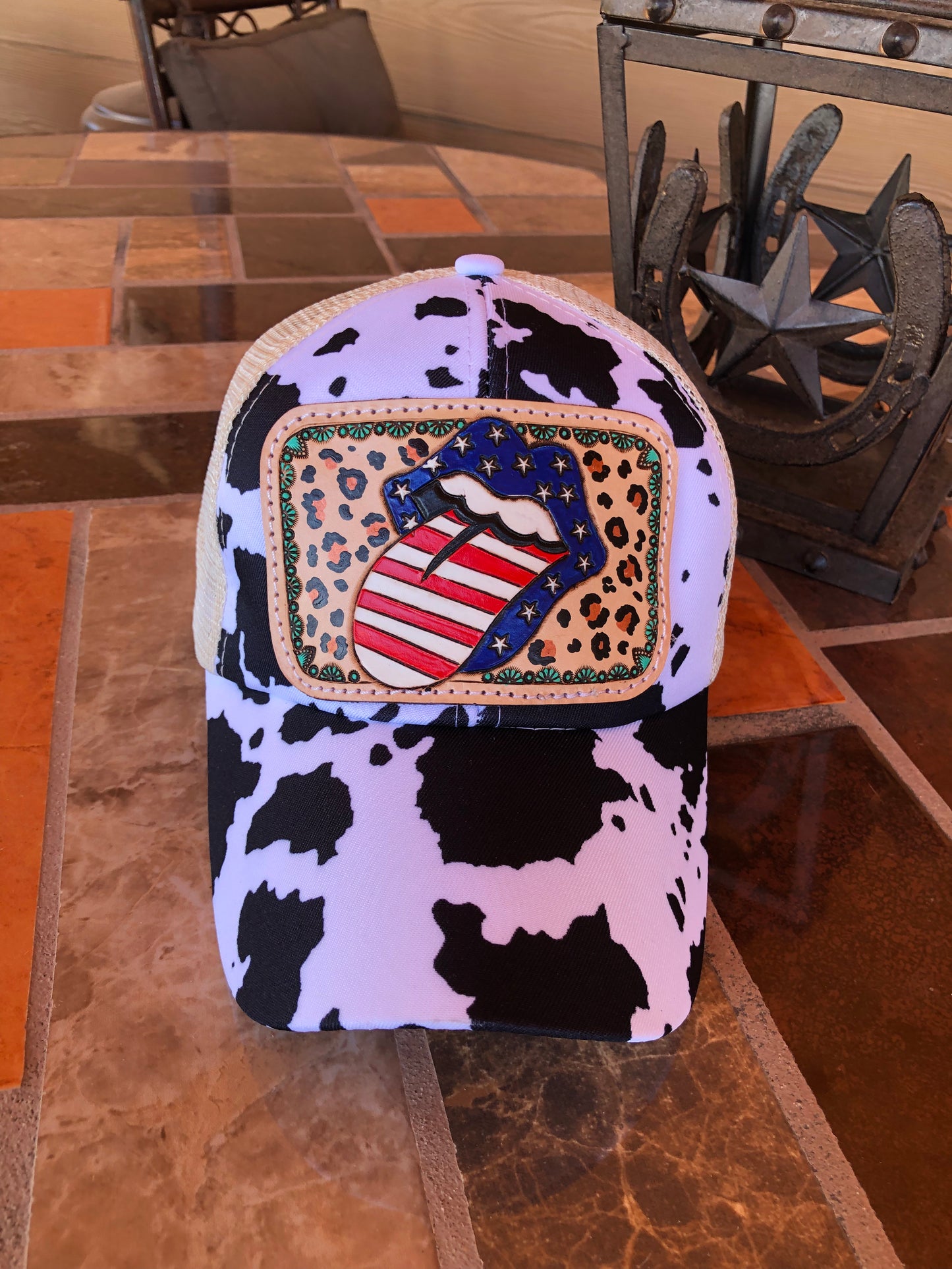 Women’s tooled leather patriotic rock n roll mouth patch cow print crisscross back trucker cap